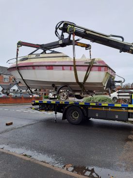 Abandoned boat on back of recovery vehicle