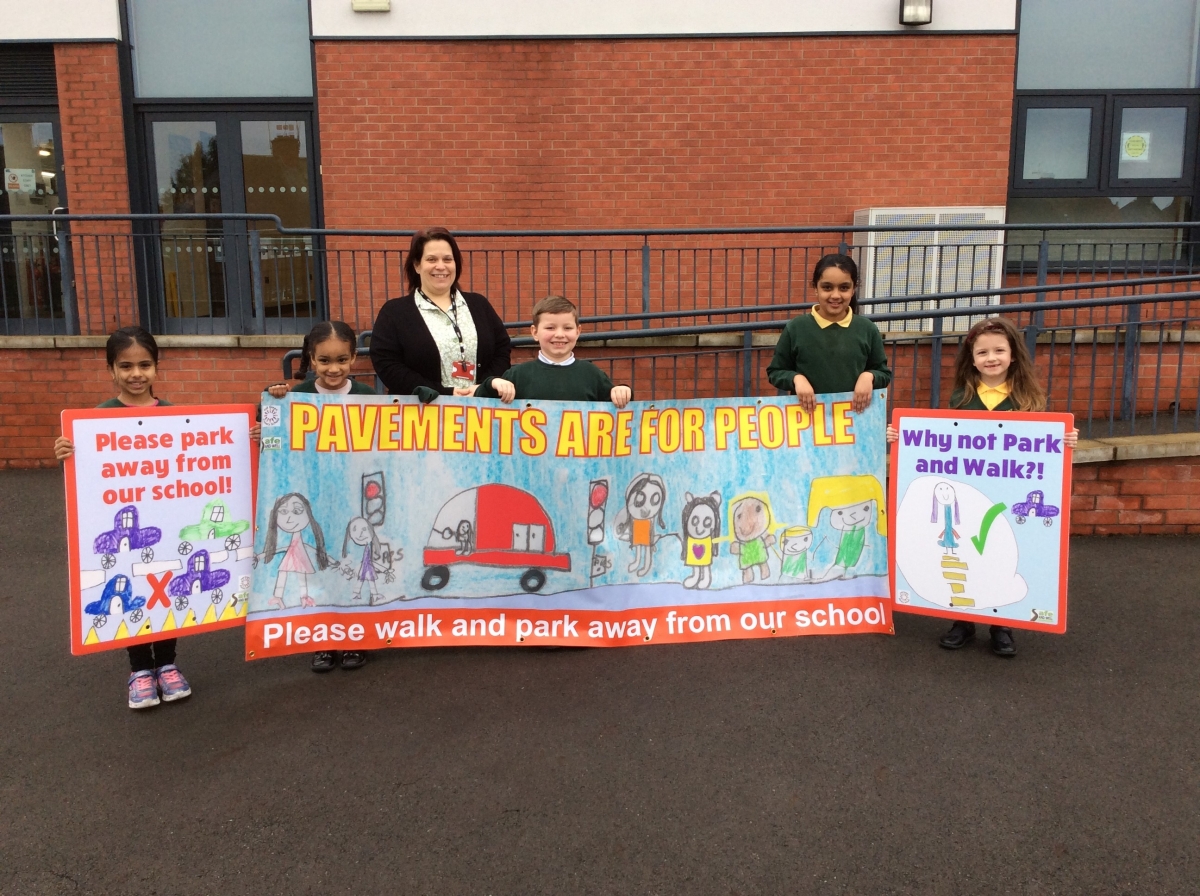 Hall Green primary school - road safety campaign - a group of one teacher and several pupils holding up a road safety banner - Rayna, Wafa, Alison Gilbert, Jameson, Zainab, Abigail
