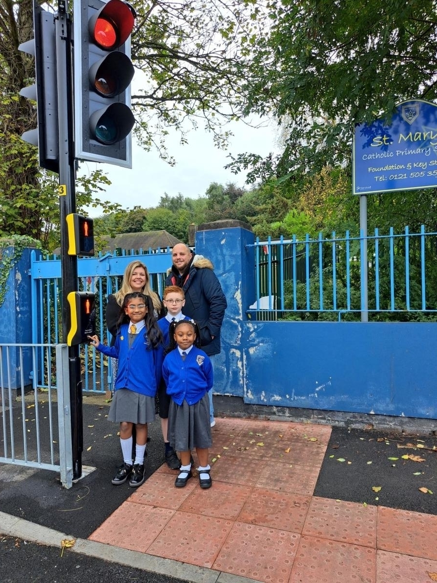 Councillor Millard standing outside the Puffin Crossing with the headteacher and three children